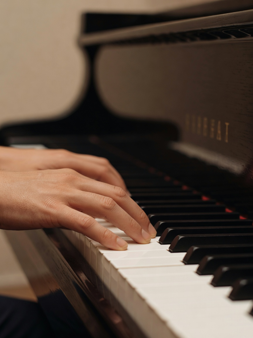 Fingers holding closely spaced chord tones on a piano keyboard